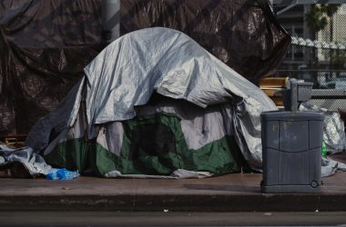 A tent outside in the middle of piles of rubbish.