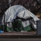 A tent outside in the middle of piles of rubbish.